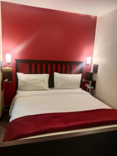a bedroom with a red headboard and a white bed at The V Sadan in Mumbai