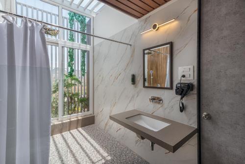 a bathroom with a sink and a window at Wabi Sabi Resort, Igatpuri in Igatpuri