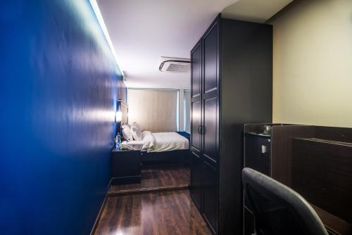 a small room with a bed and a room with a door at The V Sadan in Mumbai
