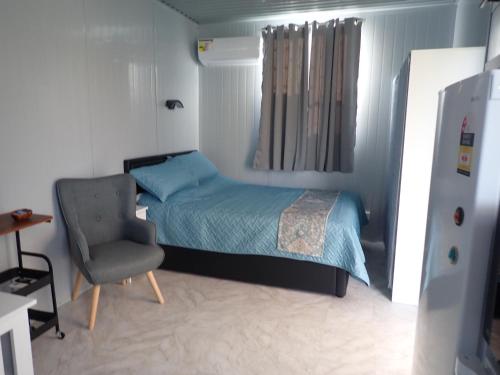 a small bedroom with a bed and a chair at Danni's Hidden Retreat in Greenmount