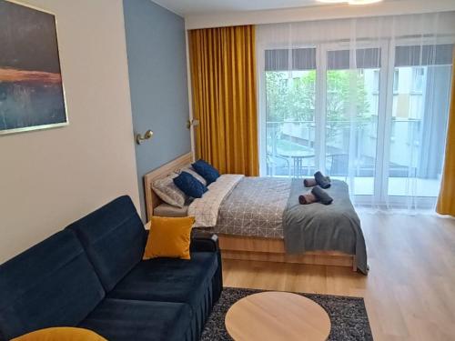 Apartament Centrum Białystok في بياويستوك: غرفة معيشة مع سرير وأريكة