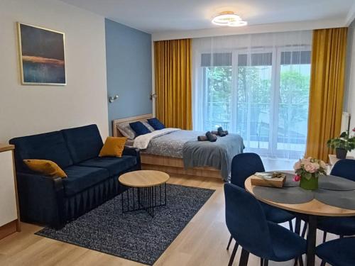 Apartament Centrum Białystok في بياويستوك: غرفة معيشة مع سرير وأريكة وطاولة