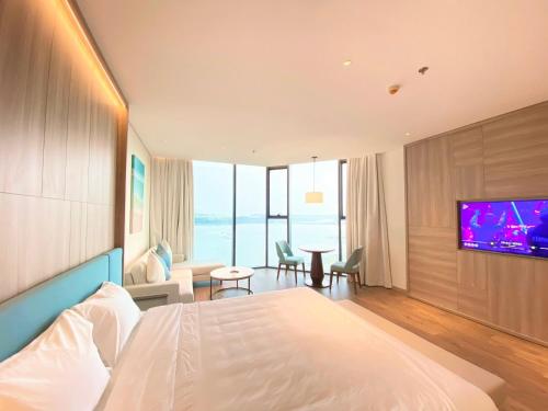 ein Hotelzimmer mit einem Bett und einem Flachbild-TV in der Unterkunft Khách sạn A LaCarte Hạ Long - Quảng Ninh in Hạ Long