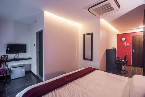 a bedroom with a bed and a tv in it at The V Sadan in Mumbai