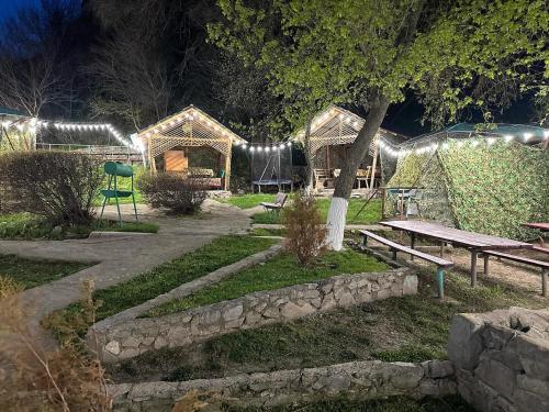 TaūtürgenにあるКомплекс Тимурの夜のベンチとピクニックテーブル付きの公園