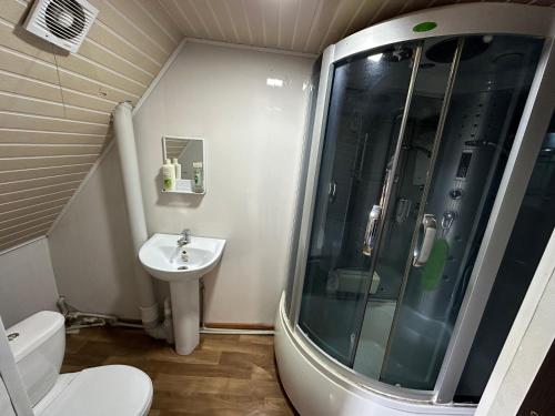 uma pequena casa de banho com um chuveiro e um lavatório. em Комплекс Тимур em Taūtürgen