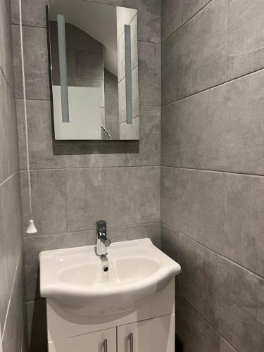 y baño con lavabo blanco y espejo. en Spencer Bridge House by AFL en Northampton
