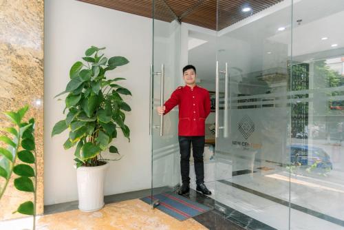 a young man standing inside of a glass wall at New Century Hotel in Hanoi