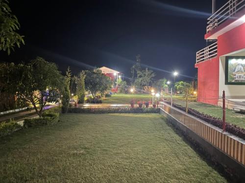 a park at night with a red building at Kanva Farms in Kotdwāra