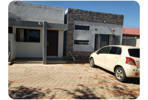 a white car parked in front of a house at The V Space in Lusaka