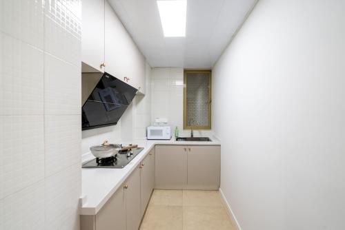 a kitchen with white cabinets and a stove top oven at Shanghai Yi Du B&B - Yu Garden Bund Store, 400m near Yu Garden subway in Shanghai