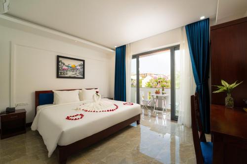 um quarto com uma grande cama branca e uma janela em May Boutique Villa Hội An em Hoi An