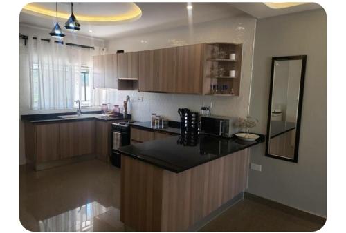 a kitchen with wooden cabinets and a black counter top at The V Space in Lusaka