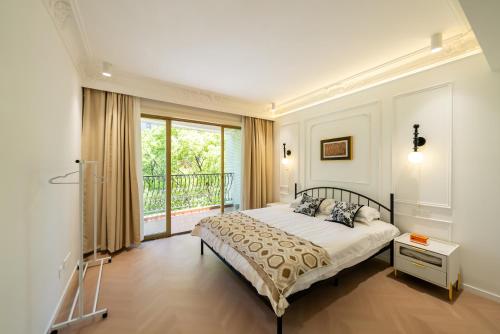 a bedroom with a bed and a balcony at Shanghai Yi Du B&B - Yu Garden Bund Store, 400m near Yu Garden subway in Shanghai