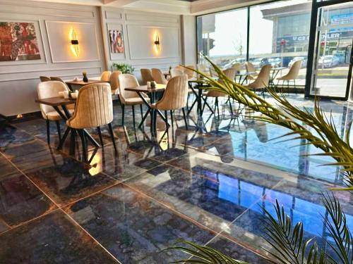 a restaurant with chairs and tables and a pool at Skymoon Airport Hotel in Arnavutköy