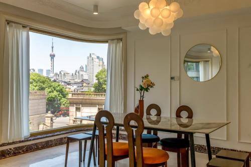 a dining room with a table and chairs and a large window at Shanghai Yi Du B&B - Yu Garden Bund Store, 400m near Yu Garden subway in Shanghai