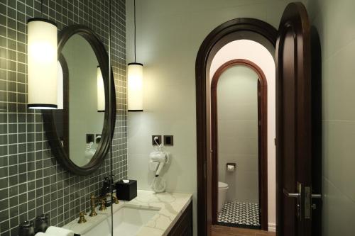 a bathroom with two mirrors and a sink at Paul Chabot Hotel in Hai Phong