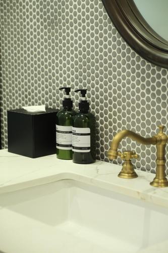 two bottles of soap sitting on a bathroom sink at Paul Chabot Hotel in Hai Phong