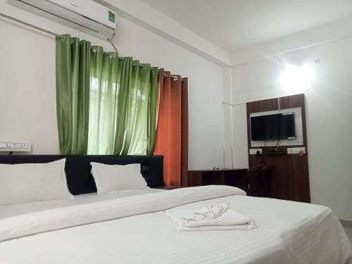 um quarto com 2 camas e uma janela com cortinas verdes em Bonobithikaloy Resort & Restaurant em Chālsa Mahābāri