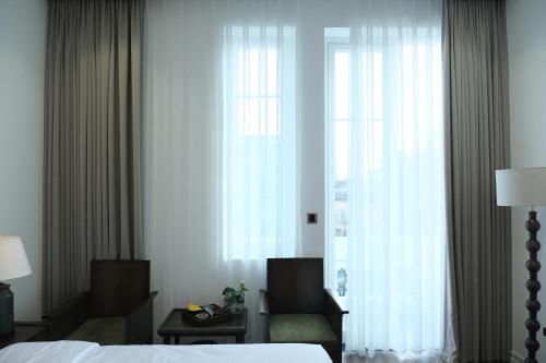 a hotel room with a bed and a window at Paul Chabot Hotel in Hai Phong