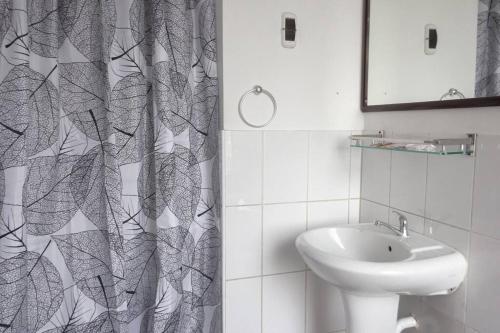 a bathroom with a sink and a shower curtain at Departamento con vista de Lima in Lima