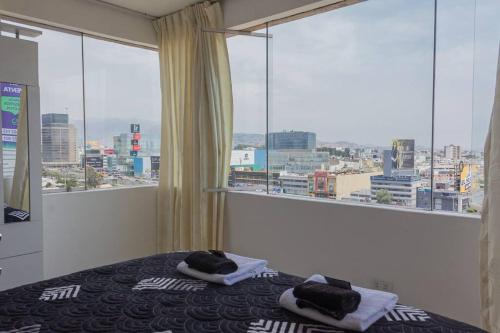 a bedroom with a bed with a view of a city at Departamento con vista de Lima in Lima