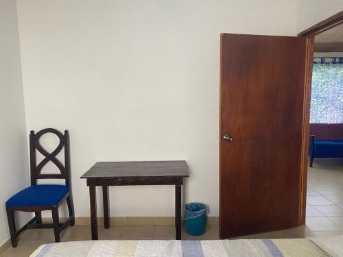 a table and a chair and a wooden door at Kochian: Lugar donde se sueña in Zoquiapan