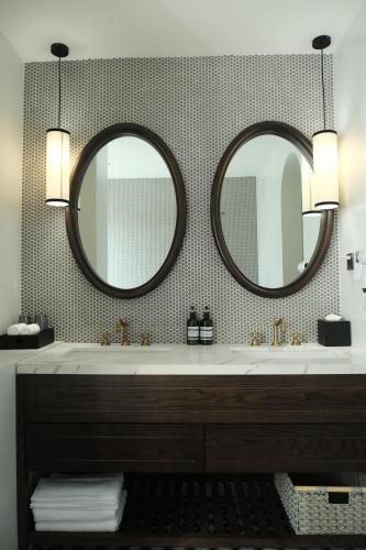 a bathroom with a sink and two mirrors at Paul Chabot Hotel in Hai Phong