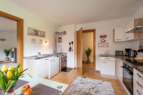 a large kitchen with white cabinets and a table at Bauernhof Unterstegen in Söll