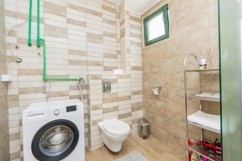 a bathroom with a washing machine and a toilet at Hotel Fobra in Podgorica