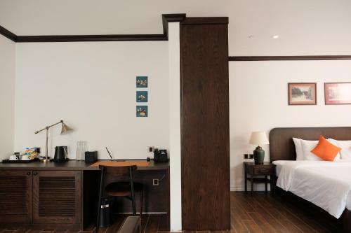 a bedroom with a desk and a bed and a bed and a desk at Paul Chabot Hotel in Hai Phong