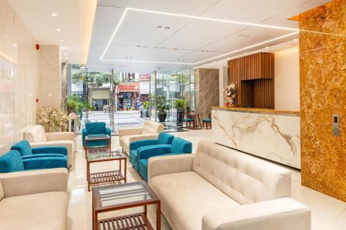a salon with couches and blue chairs in a lobby at The Summer Hotel in Nha Trang
