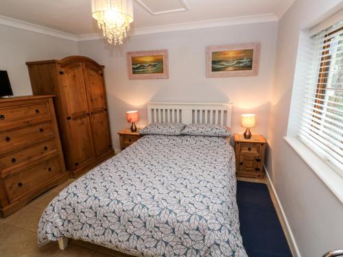 a bedroom with a bed and two night stands at Tregonning Lodge in Helston