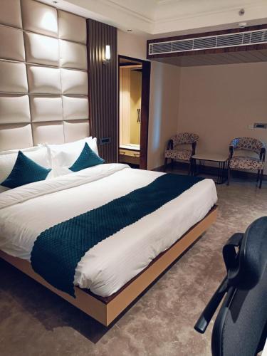 a bedroom with a large bed with blue pillows at AR Plaza in Chandīgarh