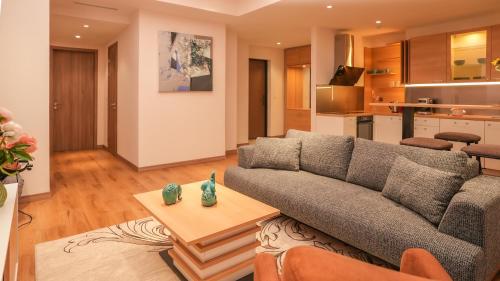 May Seven Hotel في أولان باتور: غرفة معيشة مع أريكة وطاولة