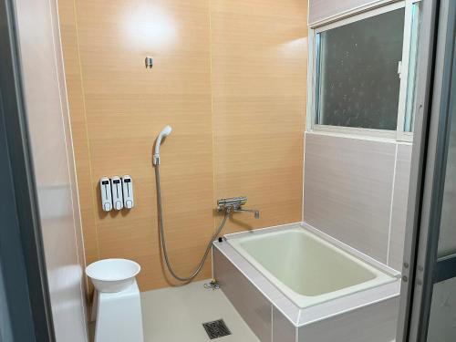 a bathroom with a tub and a toilet and a sink at 出雲のお宿中荒木 in Izumo
