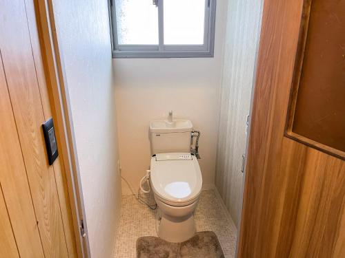 a toilet in a small bathroom with a window at 出雲のお宿中荒木 in Izumo