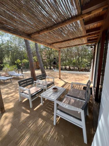 un patio con 2 sillas, una mesa y un banco en casa donatella, en Cala Liberotto