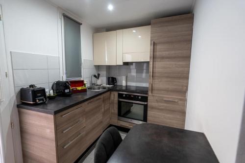 une cuisine avec des armoires en bois et un comptoir noir dans l'établissement Marcenaro, à Beausoleil