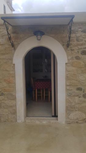 an archway in a stone building with a table at Casa Opuntia in Pappayiannádhes