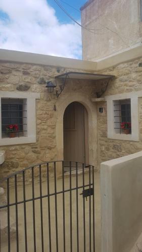 a stone building with a door and two windows at Casa Opuntia in Pappayiannádhes
