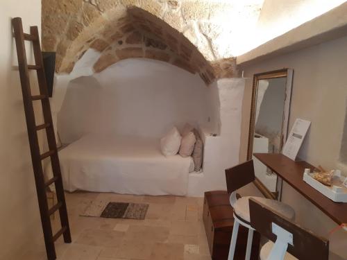 1 dormitorio con 1 cama en una habitación con una pared de ladrillo en La Segreta del Castello Self Check-in, private access en Gioia del Colle