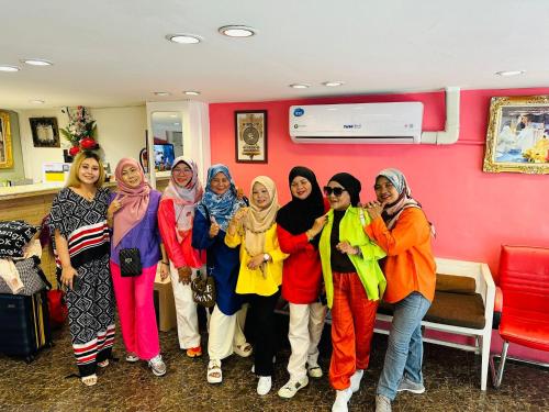 a group of women posing for a picture in a room at Miracle Gallery Hotel in Makkasan