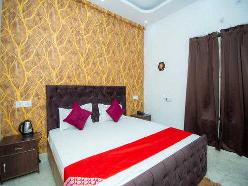 a bedroom with a large bed with purple and red pillows at Hotel Blossom in Lucknow