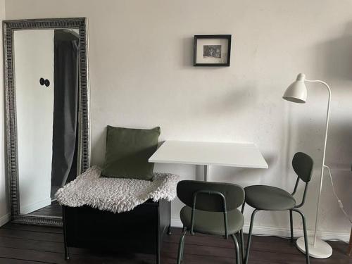 una stanza con uno specchio, un tavolo e delle sedie di Waxwing Chamber a Tallinn