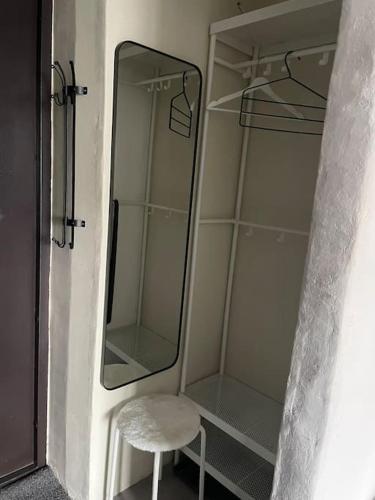 una doccia in vetro con uno sgabello bianco e uno specchio di Waxwing Chamber a Tallinn