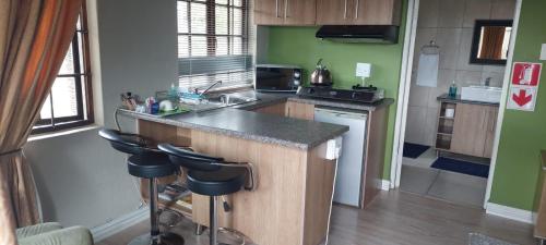 a kitchen with a counter and some stools in it at 12 On Vaal Drive Guesthouse in Vanderbijlpark