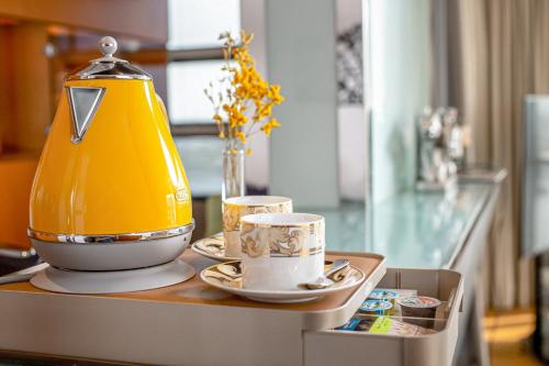 a tea kettle and two cups on a table at Golden Sands Boutique Hotel-Dubai Creek in Dubai