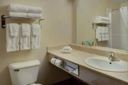 a bathroom with a sink and a toilet and a mirror at Pomeroy Inn and Suites Chetwynd in Chetwynd