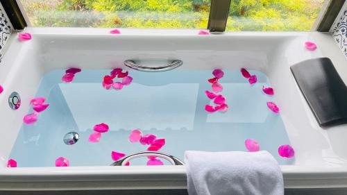 a white sink with pink flowers on it at Argyle Resort Lijiang Tujing Shuhe Ancient Town in Lijiang